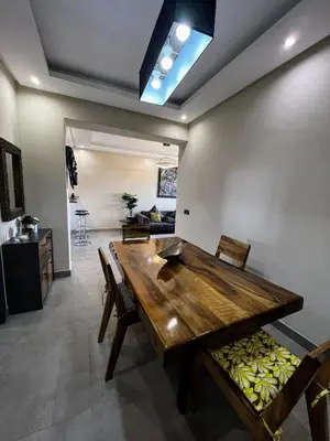a dining room with a wooden table and chairs at Moderne, lumineux & spacieux avec balcon -Central -Wifi-Smart TV-Clim in Marrakech