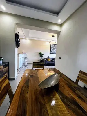 a living room with a wooden table and a couch at Moderne, lumineux & spacieux avec balcon -Central -Wifi-Smart TV-Clim in Marrakech