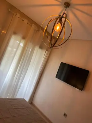 a chandelier hanging in a bedroom with a window at Appartement de Luxe -Prestigia Marrakech Golf City in Marrakech