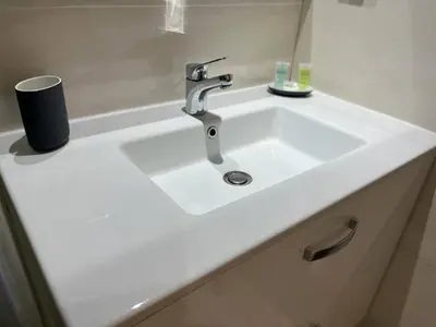 a white sink in a bathroom next to a tub at Appartement de Luxe -Prestigia Marrakech Golf City in Marrakech
