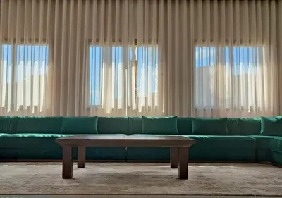 a living room with a green couch and a coffee table at Villa Naciri en plein golf avec vue sur Atlas in Marrakech