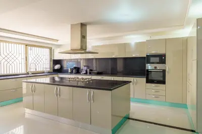 a kitchen with white cabinets and a black counter top at Villa Naciri en plein golf avec vue sur Atlas in Marrakech