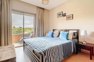 a hotel room with a bed and a balcony at Cozy Atlas Golf Studio Prestigia Marrakech in Marrakech