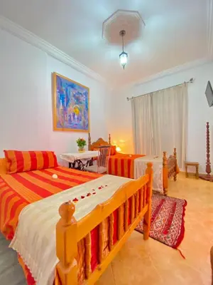 a bedroom with two beds and a couch at Dar Baddi in Marrakech