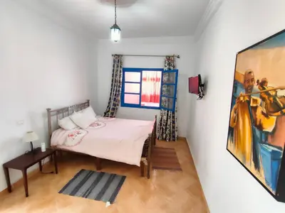 a bedroom with a bed and a painting on the wall at Dar Baddi in Marrakech