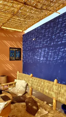 a room with a couch and a blue wall at Riad MsHolidays bassin privatisé Marrakech in Marrakech
