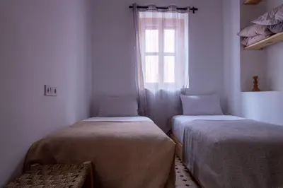 two beds in a room with a window at The Loft in Marrakech