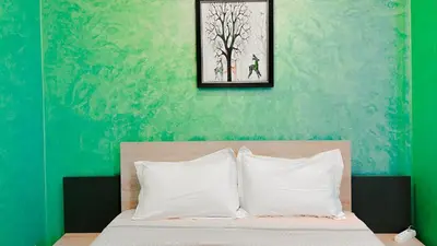 a bedroom with a bed with a green wall at BAGATELLE STUDIO GUELIZ in Marrakech