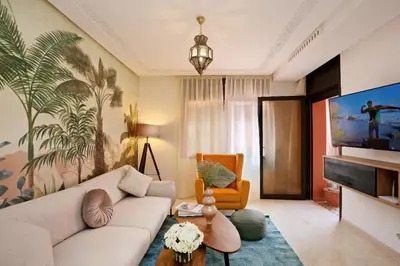 a living room with a white couch and a tv at Appartement moderne en City Center Marrakech-Gueliz in Marrakech