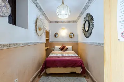 a small room with a bed and mirrors on the wall at Riad Davina in Marrakech