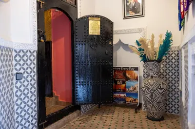 a black door and a vase in a room at Riad Davina in Marrakech