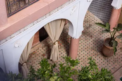 a staircase with curtains and a potted plant at Riad Davina in Marrakech