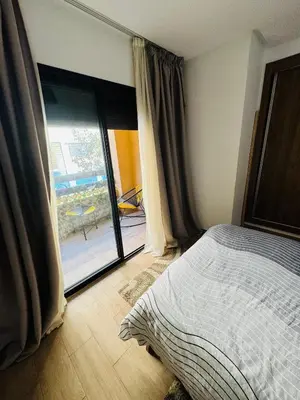 a bedroom with a bed and a door to a patio at Guéliz l’hivernage nour5 in Marrakech