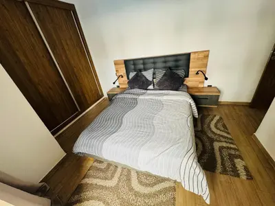 a bedroom with a large bed with a wooden headboard at Appartement de luxe et moderne in Marrakech