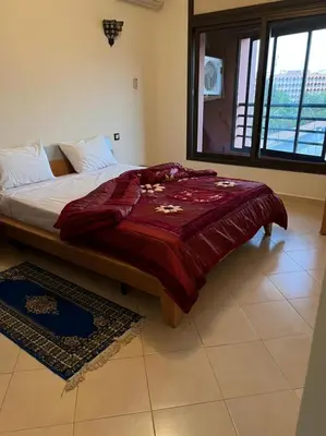 a bedroom with a bed with a red blanket on it at Résidence Caprice Palace Hivernage in Marrakech