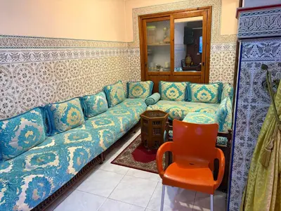 a living room with a blue couch and a chair at Dar El Azzouzi in Marrakech