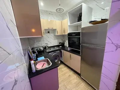 a small kitchen with a sink and a refrigerator at Dar El Azzouzi in Marrakech
