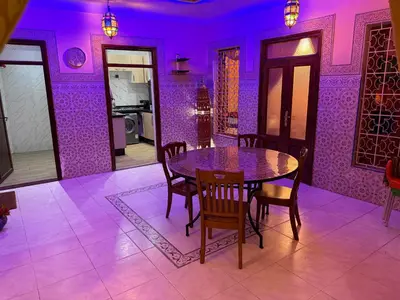 a dining room with purple walls and a table and chairs at Dar El Azzouzi in Marrakech
