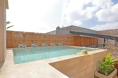 a swimming pool in a backyard with a wooden fence at Riad Amya & Spa in Marrakech