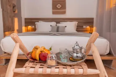a tray of fruit on a table in front of a bed at Riad Tizou in Marrakech