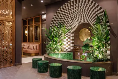 a lobby with a seating area with green stools at Riad Nyla Wellness and Spa in Marrakech