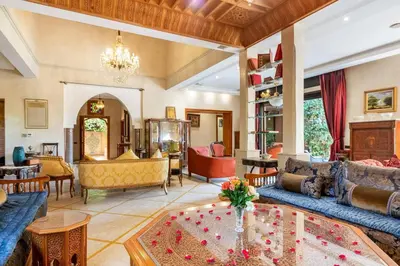a living room filled with furniture and a chandelier at Villa près de golfs in Marrakech