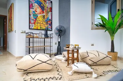 a living room with four pillows on the floor at Prestigia, superbe appartement, vue sur golf, piscine et Atlas in Marrakech
