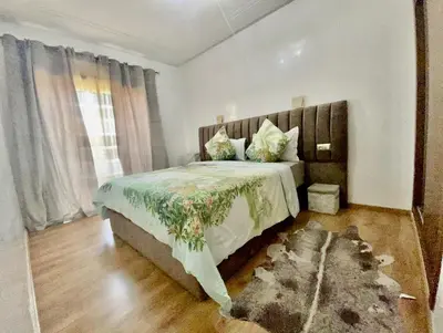a bedroom with a large bed and a window at Superbe appartement en résidence avec piscines in Marrakech
