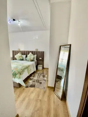 a bedroom with a bed and a mirror at Superbe appartement en résidence avec piscines in Marrakech