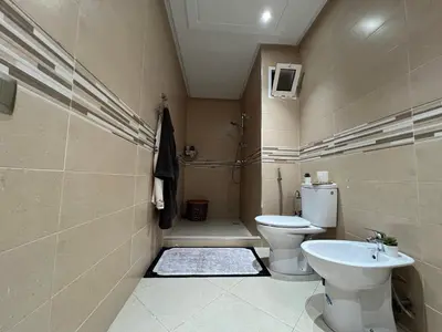 a bathroom with a toilet and a sink at Superbe appartement en résidence avec piscines in Marrakech