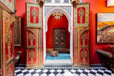 a room with a red wall with a door and a floor at Palais El Roucar in Marrakech