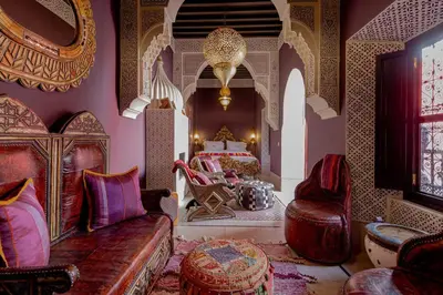 a bedroom with a bed and a couch and chairs at Palais El Roucar in Marrakech