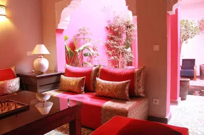 a living room with a red couch with pillows at Riad Hilmuna Hammam et Spa in Marrakech