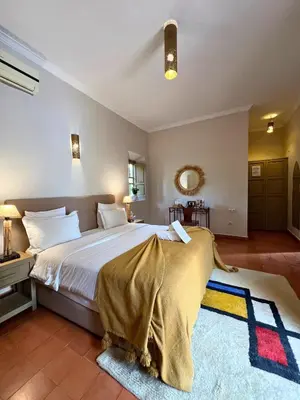 a bedroom with a large bed and a mirror at Villa Nour in Marrakech