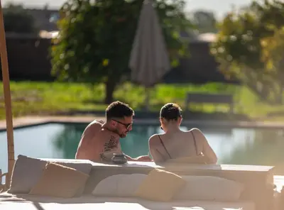 a man and a woman sitting in a swimming pool at Villa Nour in Marrakech