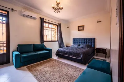 a bedroom with a bed and a couch and a chair at Cosy Villa Sabah With Private Pool in Marrakech