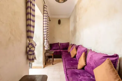 a living room with a purple couch in a room at Riad les épices in Marrakech