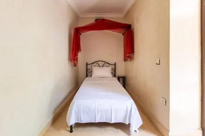 a bedroom with a bed with a red canopy at Riad les épices in Marrakech