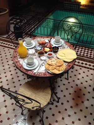a table with breakfast food on it in a room at Riad Mounlight in Marrakech