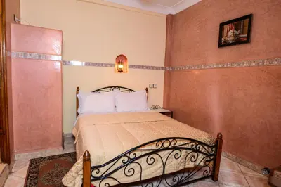 a bedroom with a bed in a room at Hôtel Faouzi in Marrakech