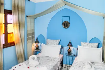 two beds in a blue room with swans on them at Riad La Famille in Marrakech
