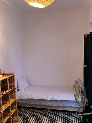 a room with a bed and a fan at Riad TaTam House in Marrakech