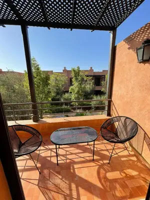 two chairs and a table on a balcony at villa jardin de l'Atlas in Marrakech