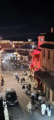 a group of people in a street at night at Marrakech medina inn in Marrakech