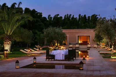 a patio with a table and chairs next to a pool at Pavillon Terra Ababila en Exclusivité in Marrakech