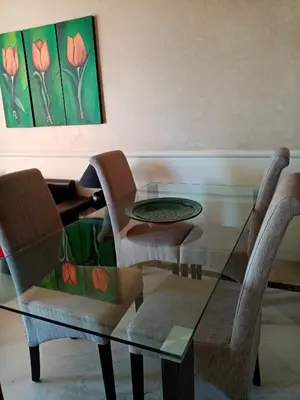 a glass dining room table with two chairs and a painting at HERMINIE ATLAS in Marrakech