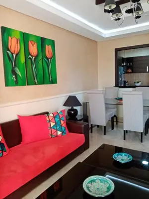 a living room with a red couch and a dining room at HERMINIE ATLAS in Marrakech