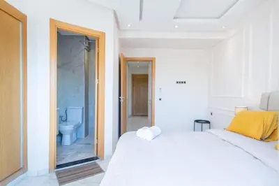 a bedroom with a bed and a bathroom with a toilet at NEW! Cosy, Lux , Gueliz centre, Iptv in Marrakech