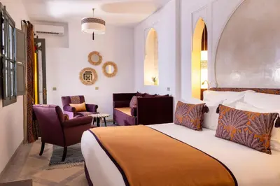a hotel room with a bed and two chairs at Riad LAZ Mimoun & Spa in Marrakech