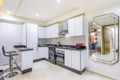 a kitchen with white cabinets and a sink and a dishwasher at Relax, Modern, Centre Gueliz in Marrakech